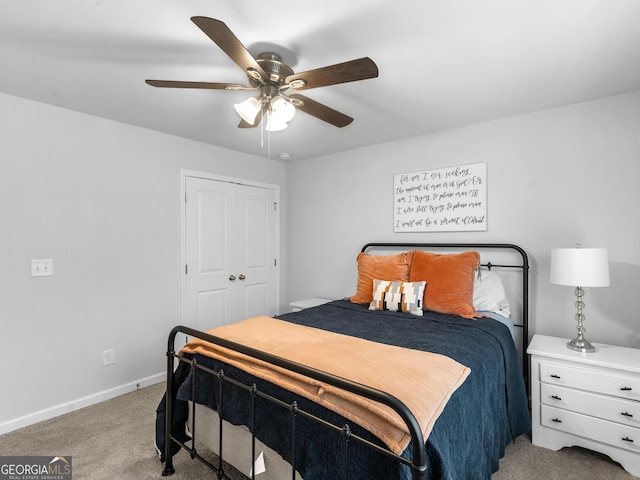 carpeted bedroom featuring ceiling fan and a closet