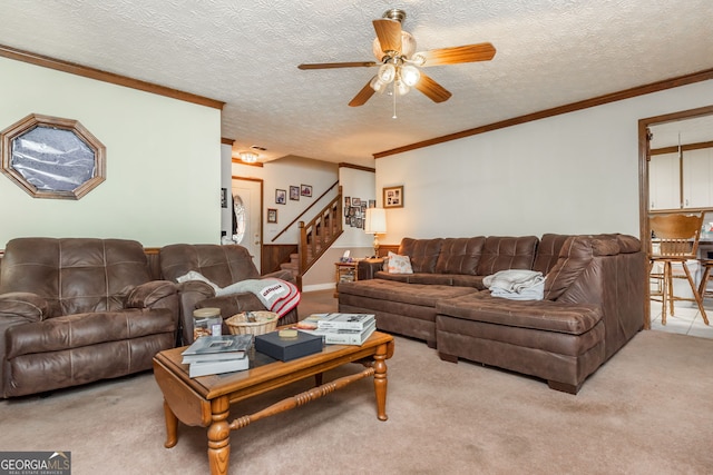 living room with a textured ceiling, ornamental molding, light carpet, and ceiling fan