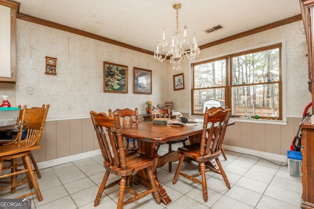 tiled dining room with a textured ceiling, crown molding, and a notable chandelier