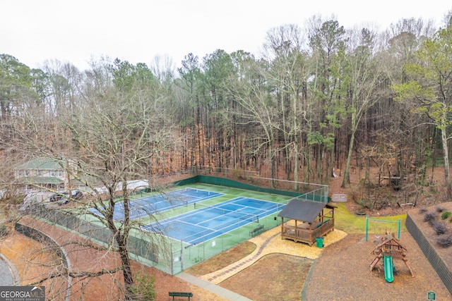 view of tennis court with a playground