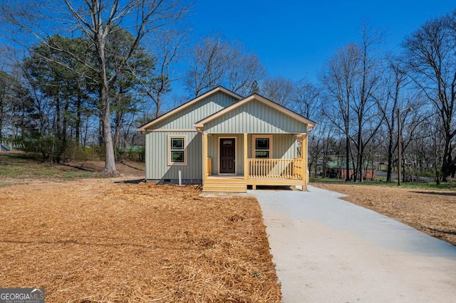 view of front of property with crawl space, board and batten siding, a porch, and concrete driveway