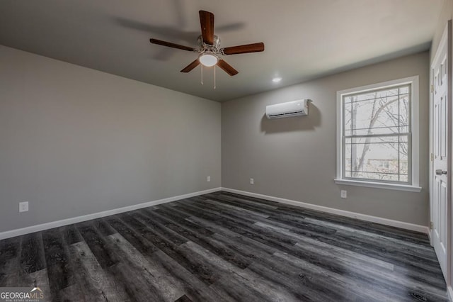 spare room featuring baseboards, dark wood-type flooring, and a wall unit AC