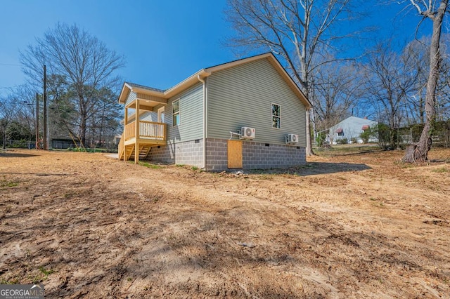 view of side of property with crawl space and stairway