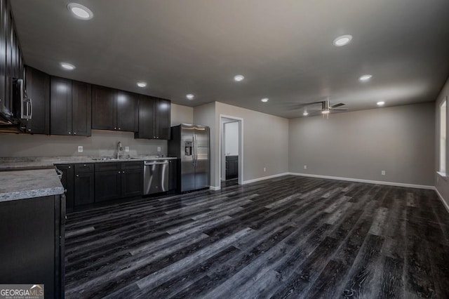 kitchen featuring a ceiling fan, a sink, light countertops, dark wood-type flooring, and appliances with stainless steel finishes