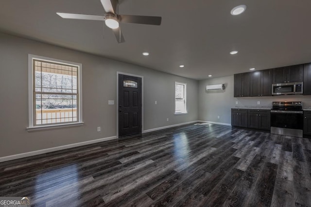 unfurnished living room with a wall mounted air conditioner, dark wood-style floors, recessed lighting, baseboards, and ceiling fan