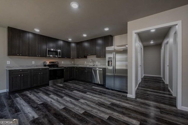 kitchen featuring dark wood finished floors, recessed lighting, stainless steel appliances, and a sink