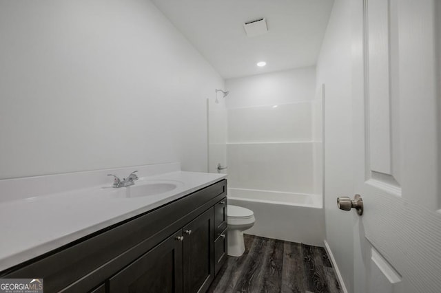 bathroom featuring tub / shower combination, toilet, vanity, and wood finished floors