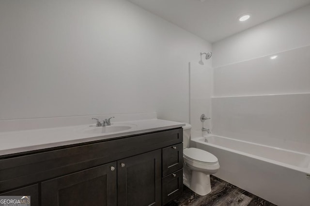 bathroom featuring toilet, shower / washtub combination, wood finished floors, and vanity