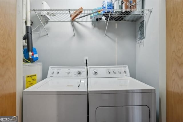 washroom with water heater and separate washer and dryer