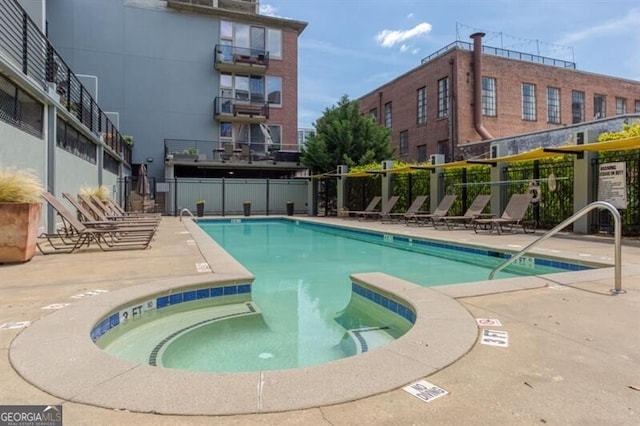 view of swimming pool with a hot tub