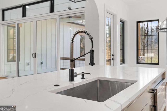 kitchen with light stone countertops and a sink