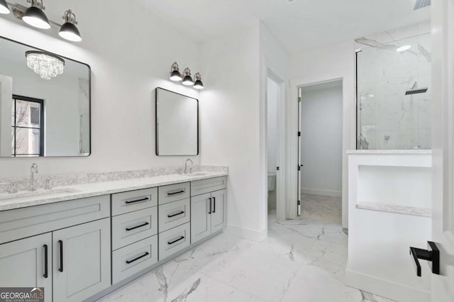 bathroom with baseboards, a marble finish shower, double vanity, a sink, and marble finish floor