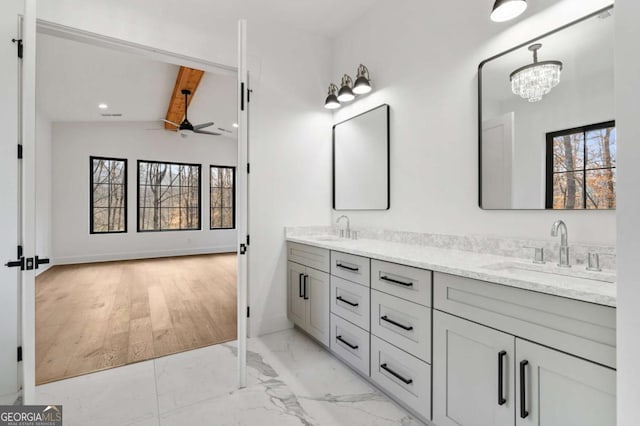 bathroom featuring a sink, marble finish floor, lofted ceiling with beams, and double vanity