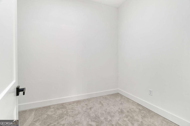 spare room featuring carpet flooring and baseboards