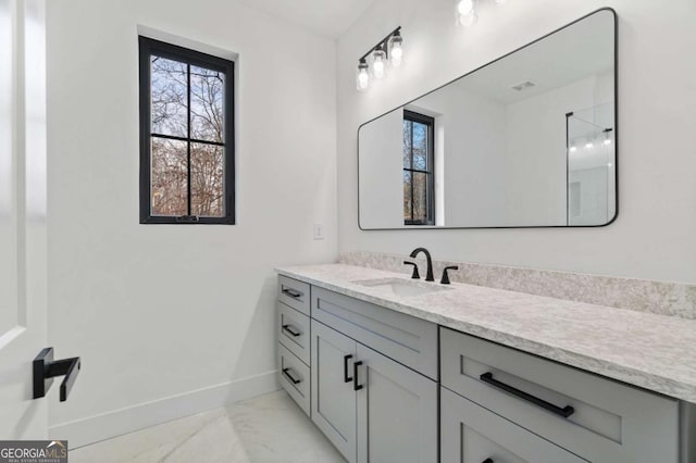 bathroom featuring vanity, baseboards, and marble finish floor