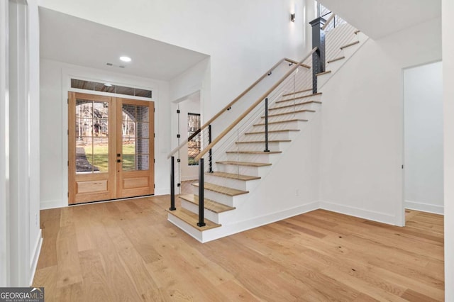 entryway featuring stairs, wood finished floors, french doors, and baseboards