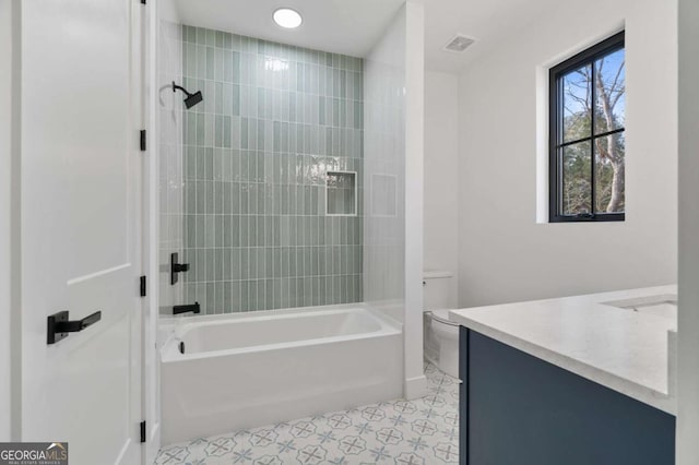 bathroom with vanity, toilet, visible vents, and shower / washtub combination