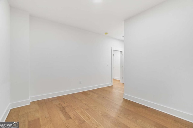 empty room featuring baseboards and light wood-style flooring