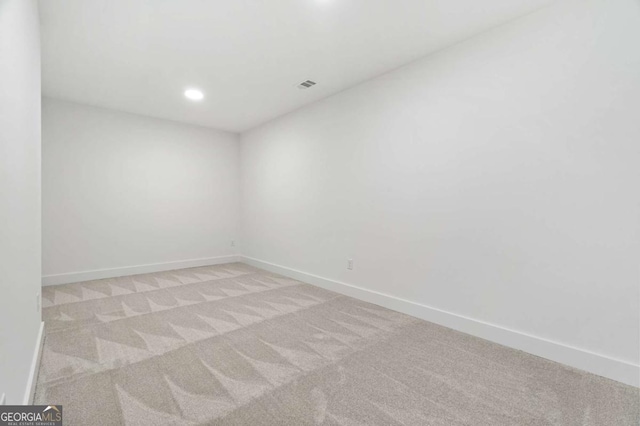 unfurnished room with light colored carpet, visible vents, and baseboards