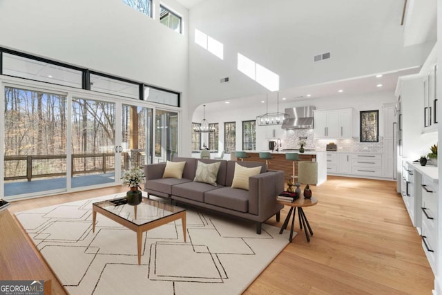 living room with a wealth of natural light, visible vents, and light wood-style floors