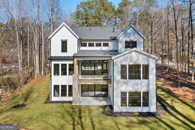 rear view of property featuring a patio area, a lawn, and roof with shingles