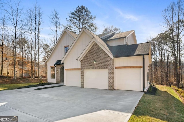 view of front of property featuring a garage, brick siding, driveway, and roof with shingles