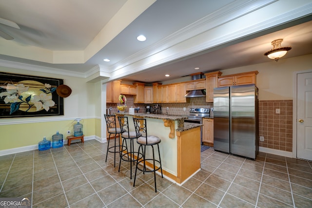 kitchen with a breakfast bar area, appliances with stainless steel finishes, light tile patterned floors, ornamental molding, and stone countertops