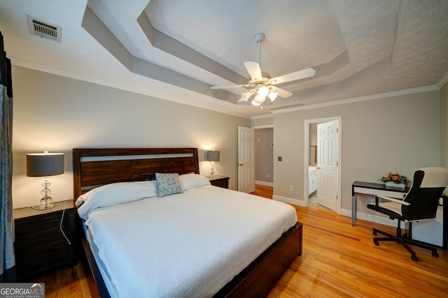 bedroom featuring ceiling fan, crown molding, light hardwood / wood-style flooring, and a raised ceiling