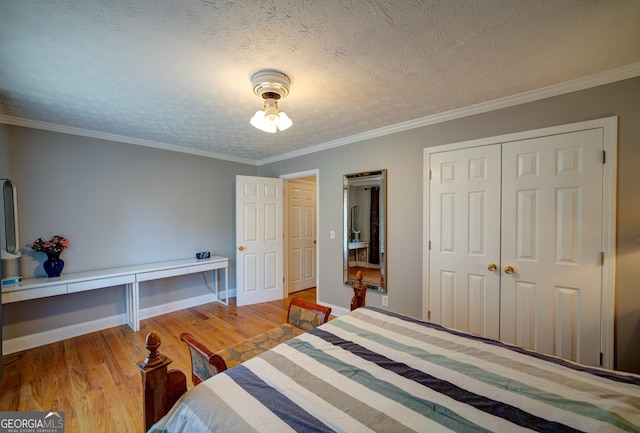 bedroom with a closet, hardwood / wood-style floors, a textured ceiling, and crown molding