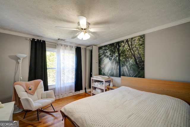 bedroom featuring ceiling fan, hardwood / wood-style floors, crown molding, and a textured ceiling