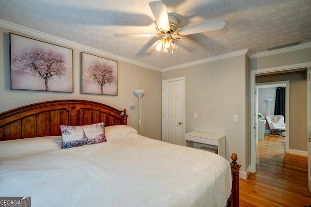 bedroom featuring a textured ceiling, ceiling fan, hardwood / wood-style flooring, and ornamental molding