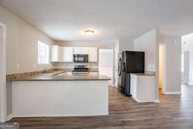 kitchen featuring kitchen peninsula, a textured ceiling, black appliances, white cabinets, and sink