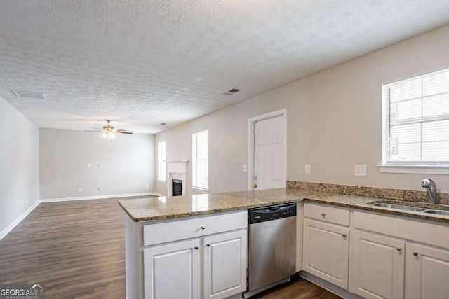 kitchen featuring kitchen peninsula, stainless steel dishwasher, white cabinets, ceiling fan, and sink