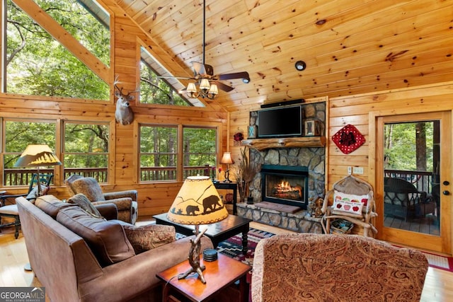 living room with high vaulted ceiling, ceiling fan, a fireplace, and wood walls