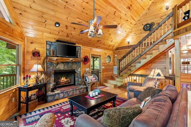 living room with wood ceiling, a fireplace, hardwood / wood-style floors, and wooden walls