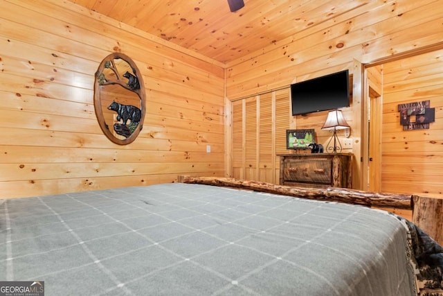 bedroom with a closet, wooden walls, and wooden ceiling