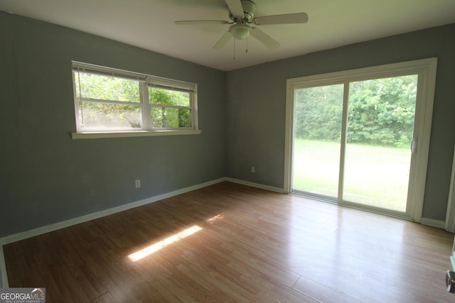 unfurnished room with ceiling fan, a wealth of natural light, and hardwood / wood-style flooring