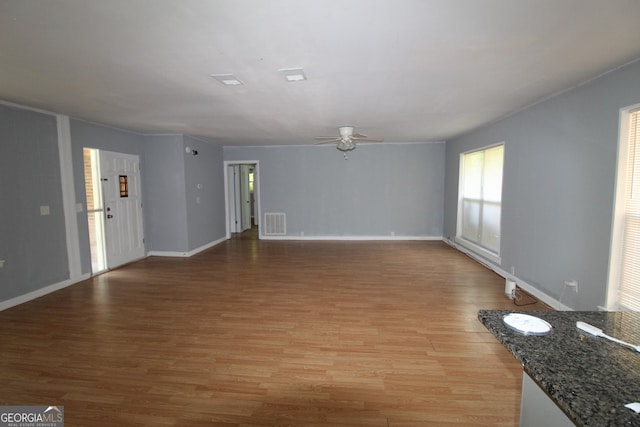 unfurnished living room featuring light wood-type flooring and ceiling fan