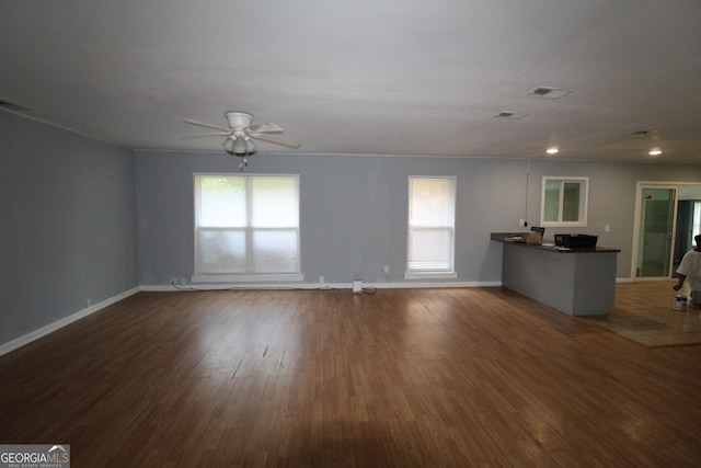 unfurnished living room featuring ceiling fan and dark hardwood / wood-style floors