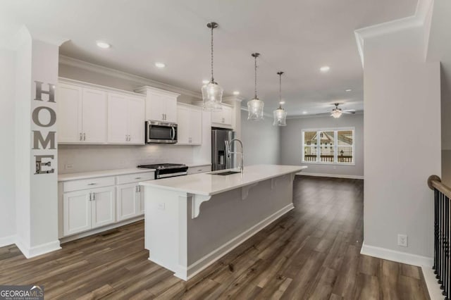 1708 Evenstad Way, Smyrna, GA 30080 - kitchen featuring appliances with stainless steel finishes, white cabinetry, light countertops, a kitchen island with sink, and ornamental molding