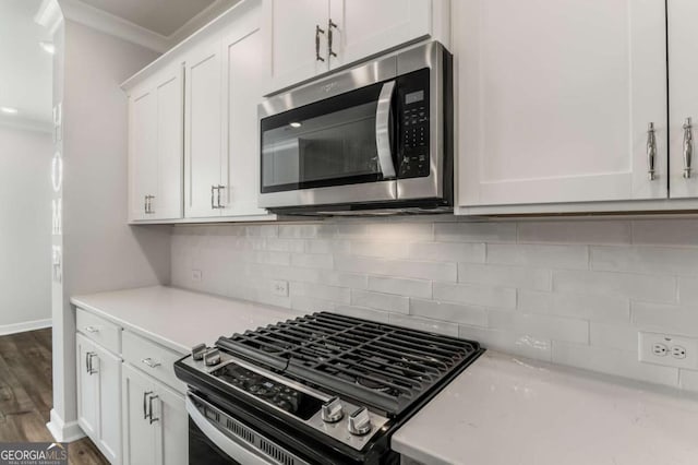 1708 Evenstad Way, Smyrna, GA 30080 - kitchen featuring stainless steel appliances, light countertops, crown molding, white cabinets, and decorative backsplash