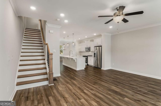 unfurnished living room with ceiling fan, sink, crown molding, and dark hardwood / wood-style floors