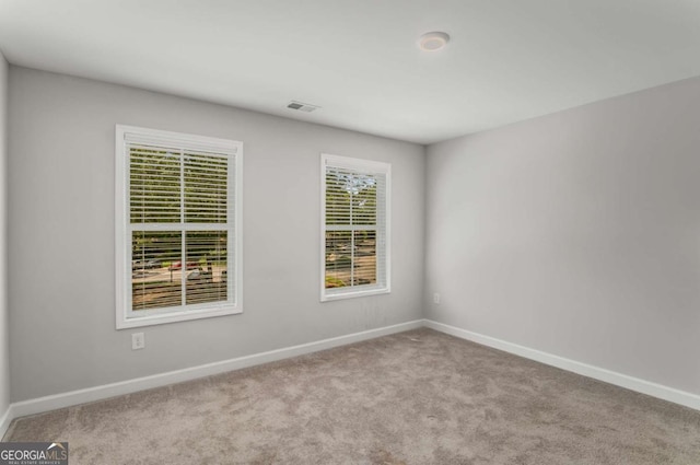 spare room featuring light carpet