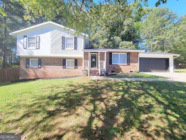 tri-level home featuring a garage and a front lawn