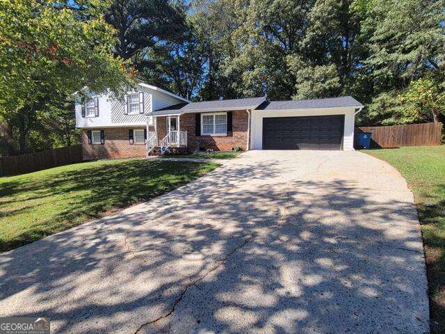 tri-level home with a garage and a front lawn