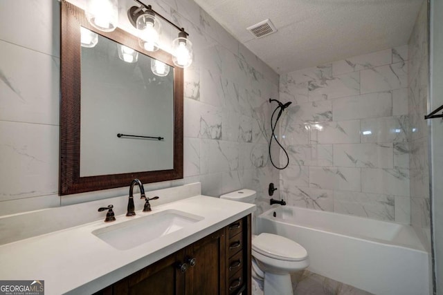 full bathroom featuring tiled shower / bath combo, toilet, vanity, tile walls, and a textured ceiling