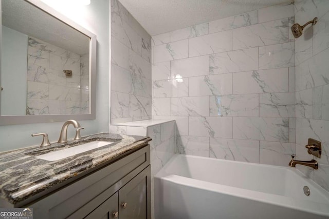 bathroom featuring tiled shower / bath combo, a textured ceiling, and vanity