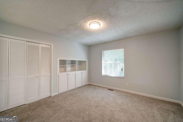 unfurnished bedroom with a textured ceiling and carpet flooring