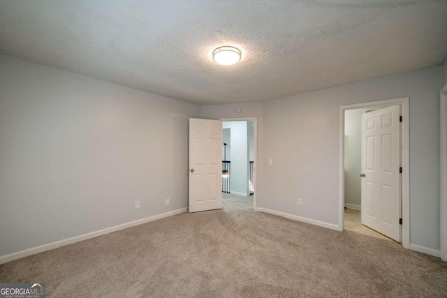 unfurnished bedroom featuring light colored carpet and a textured ceiling