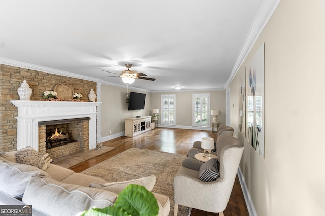 living room featuring a fireplace, ceiling fan, ornamental molding, and hardwood / wood-style floors